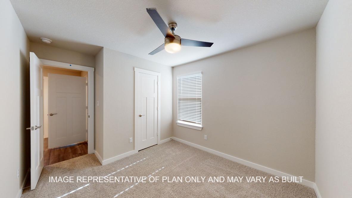 Caden secondary bedroom with carpet flooring and window.