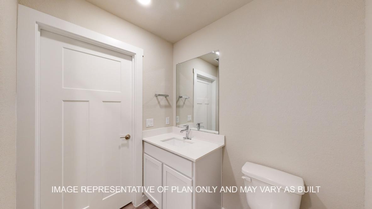 Caden powder bath with single vanity and toilet.