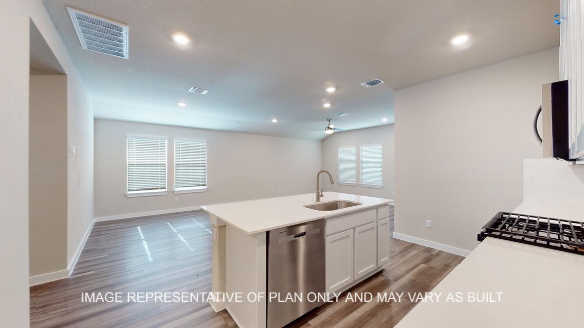 Caden kitchen with view to open living and dining room and windows to the backyard.
