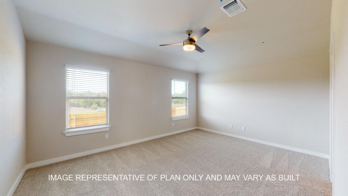 Caden primary bedroom with carpet flooring and windows to backyard.