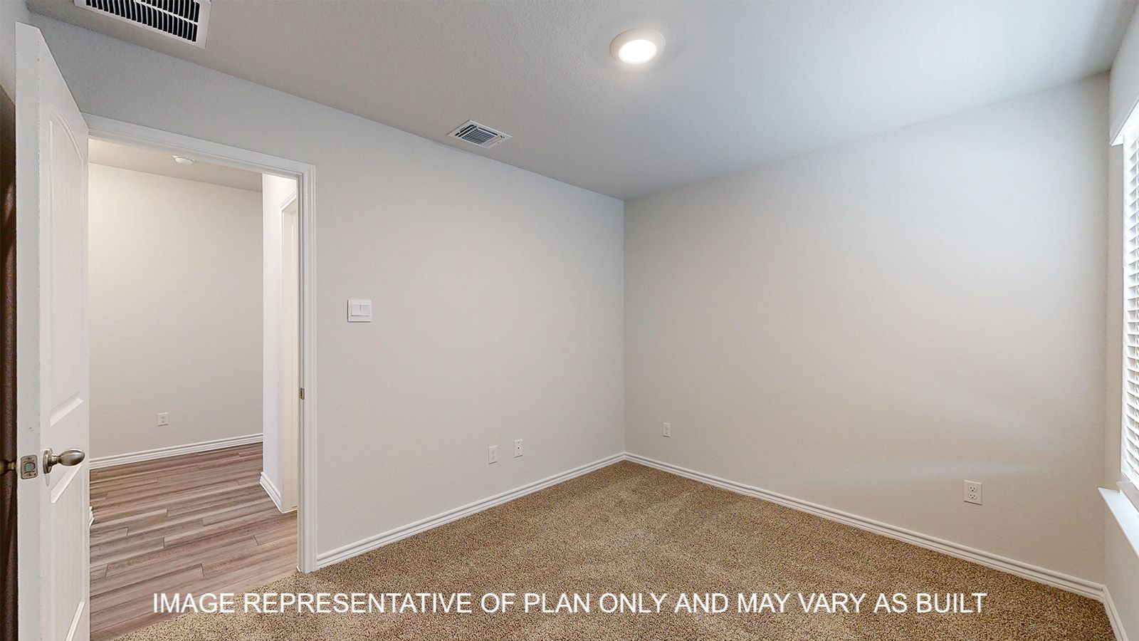 Alpine secondary bedroom with carpet flooring and view into hallway.