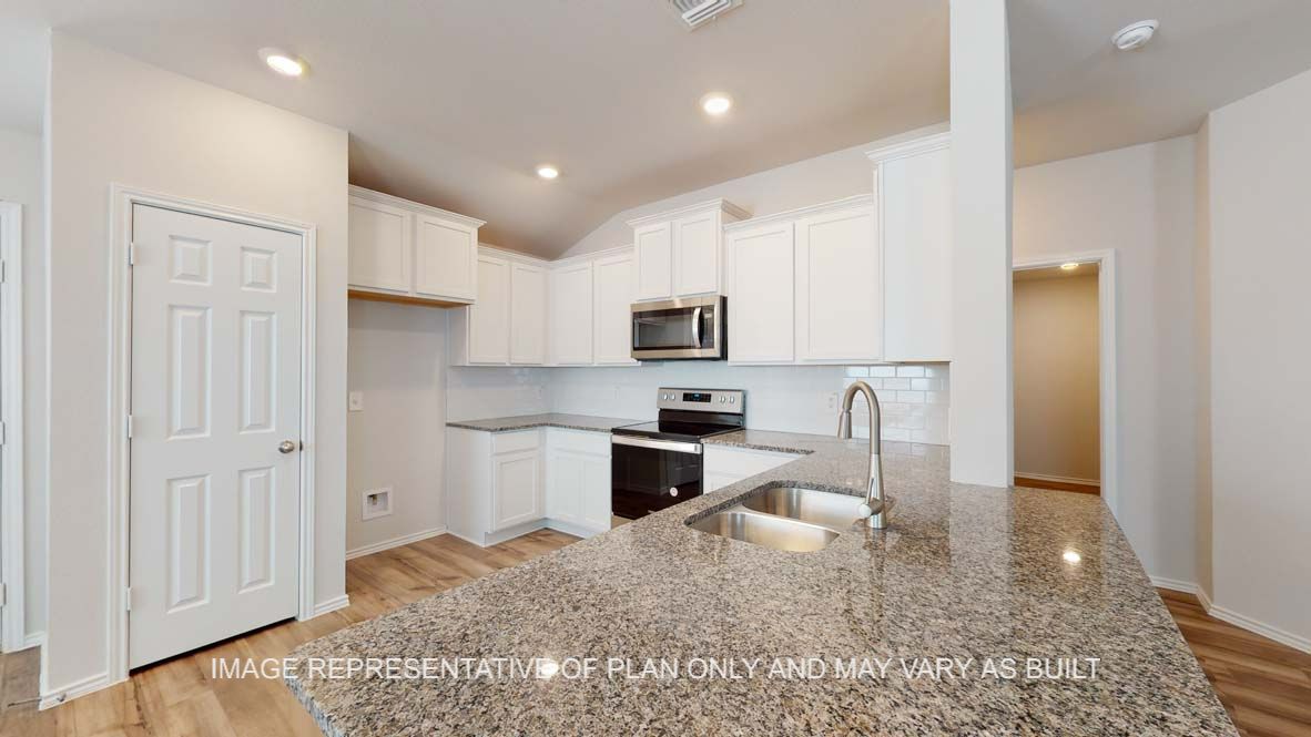 Roosevelt kitchen with white cabinets and stainless appliances.
