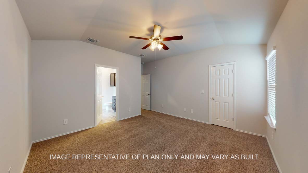 Roosevelt primary bedroom with carpet flooring and view into attached bathroom.