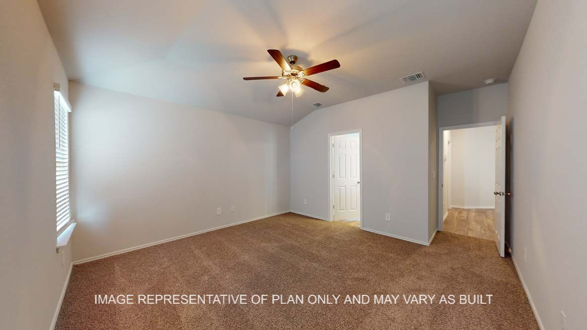 Roosevelt primary bedroom with carpet flooring and view into attached bathroom.