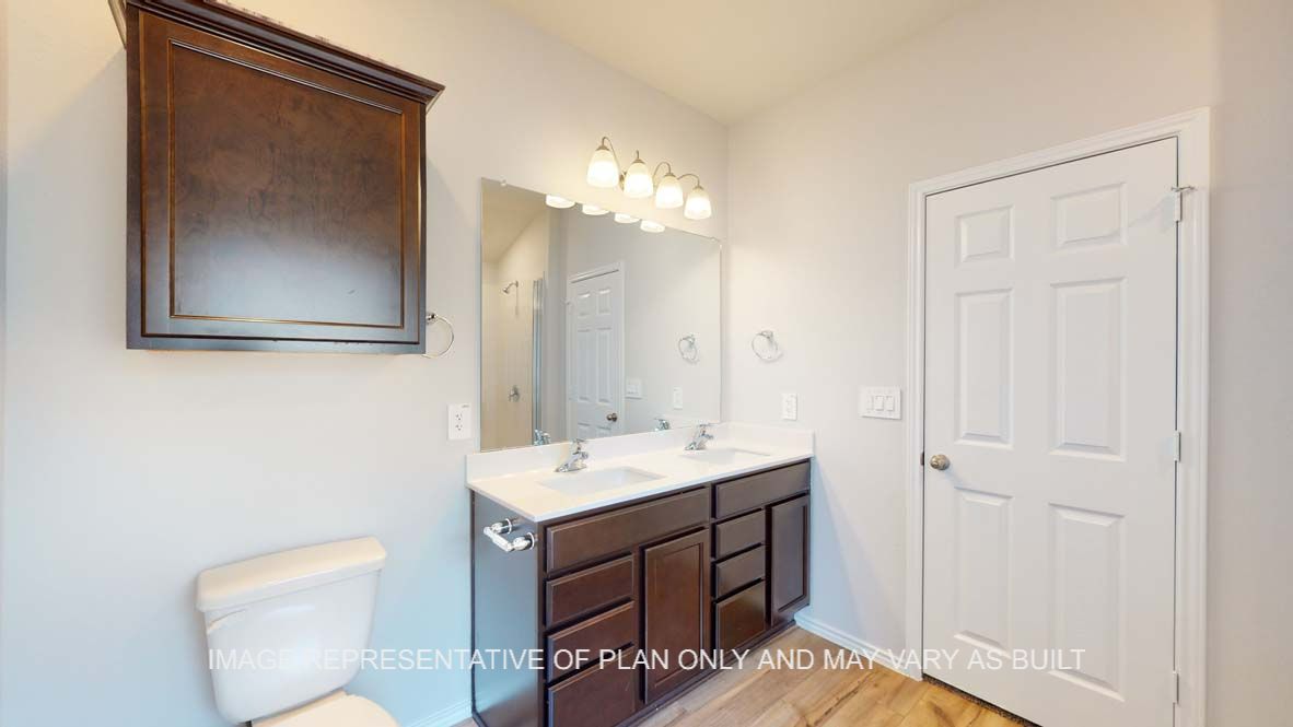 Roosevelt primary bathroom with dark cabinets and white countertops.