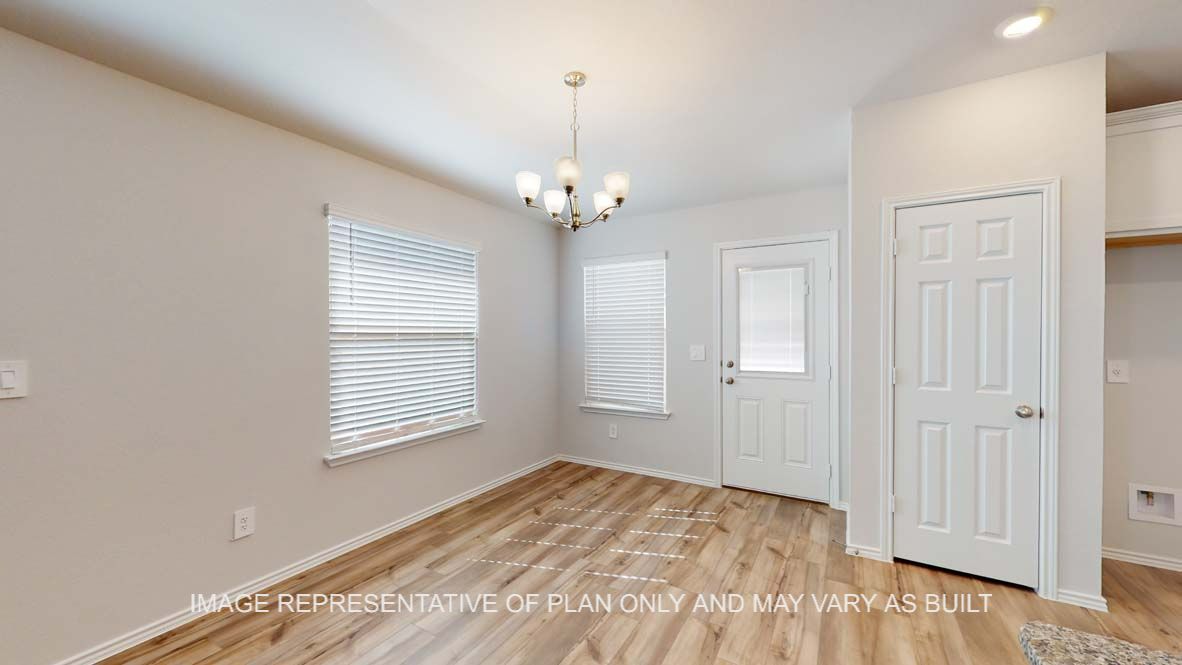 Roosevelt dining room with vinyl plank flooring and door to the back patio.