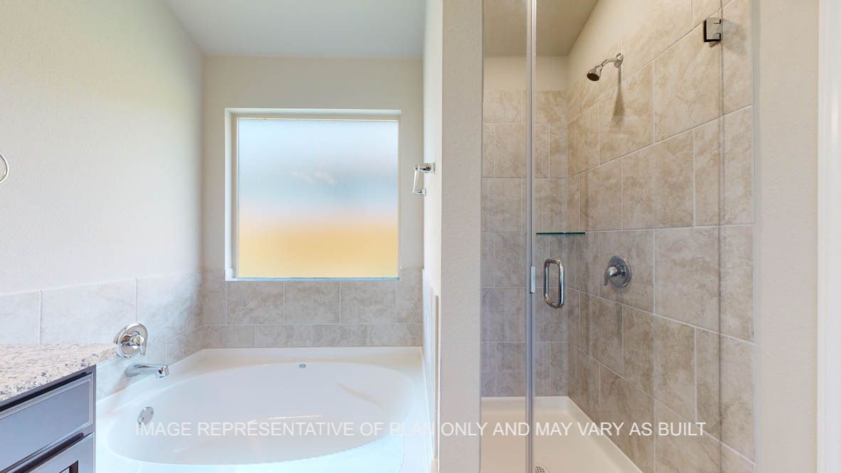 Richmond primary bathroom with separate tub and shower with ceramic tile surround with clear shower glass enclosure.