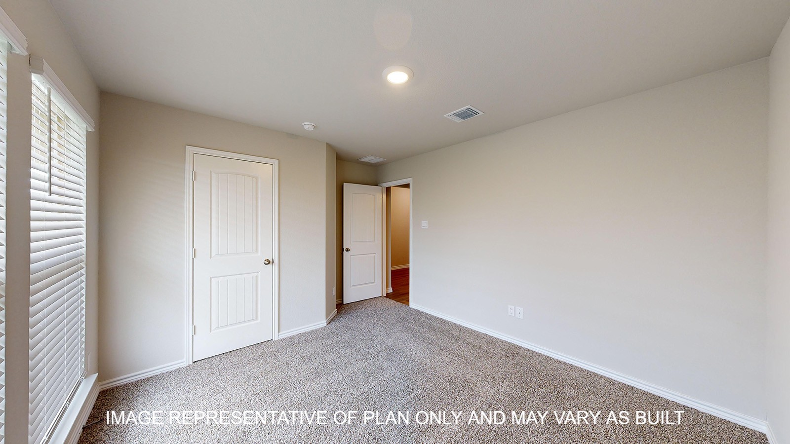 Monroe secondary bedroom with carpet flooring and closet door.