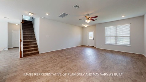 Aspen living room with vinyl plank flooring throughout and access to stairs.