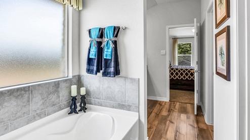 Three Creeks Colt Creek model home primary bathroom with a soaking tub.