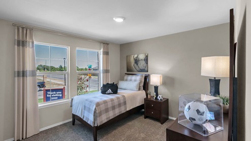 Park Meadows model home secondary bedroom with a twin bed and carpet flooring.