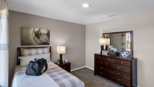 Park Meadows model home secondary bedroom with a twin bed and accent decor.
