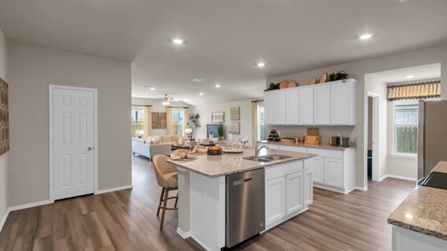 Park Meadows model home kitchen with white cabinets and granite countertops.