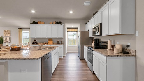 Park Meadows model home kitchen with white cabinets and granite countertops.