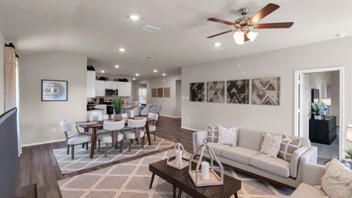 Park Meadows model home living room with open concept of the dining room and kitchen.