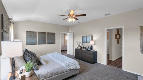 Park Meadows model home primary bedroom with a king bed and accent decor.