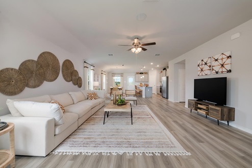 Foxborough model home living room open concept with the dining room and kitche.