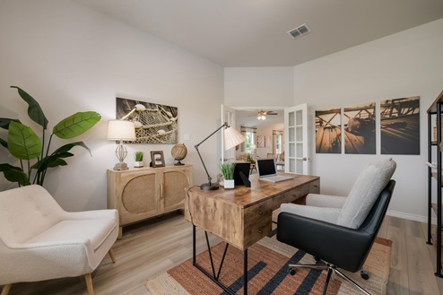 Foxborough model home secondary bedroom with storage shelving and a office desk and chair.