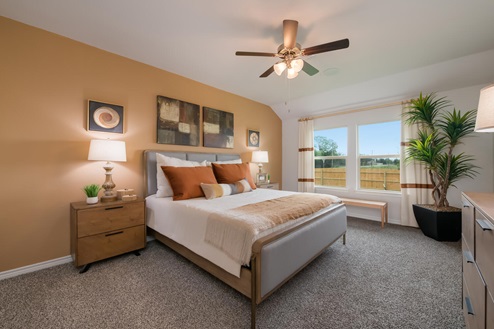 Foxborough model home primary bedroom with a king bed and accent decor.