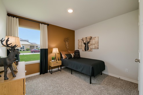 Foxborough model home secondary bedroom with a twin bed and carpet flooring.