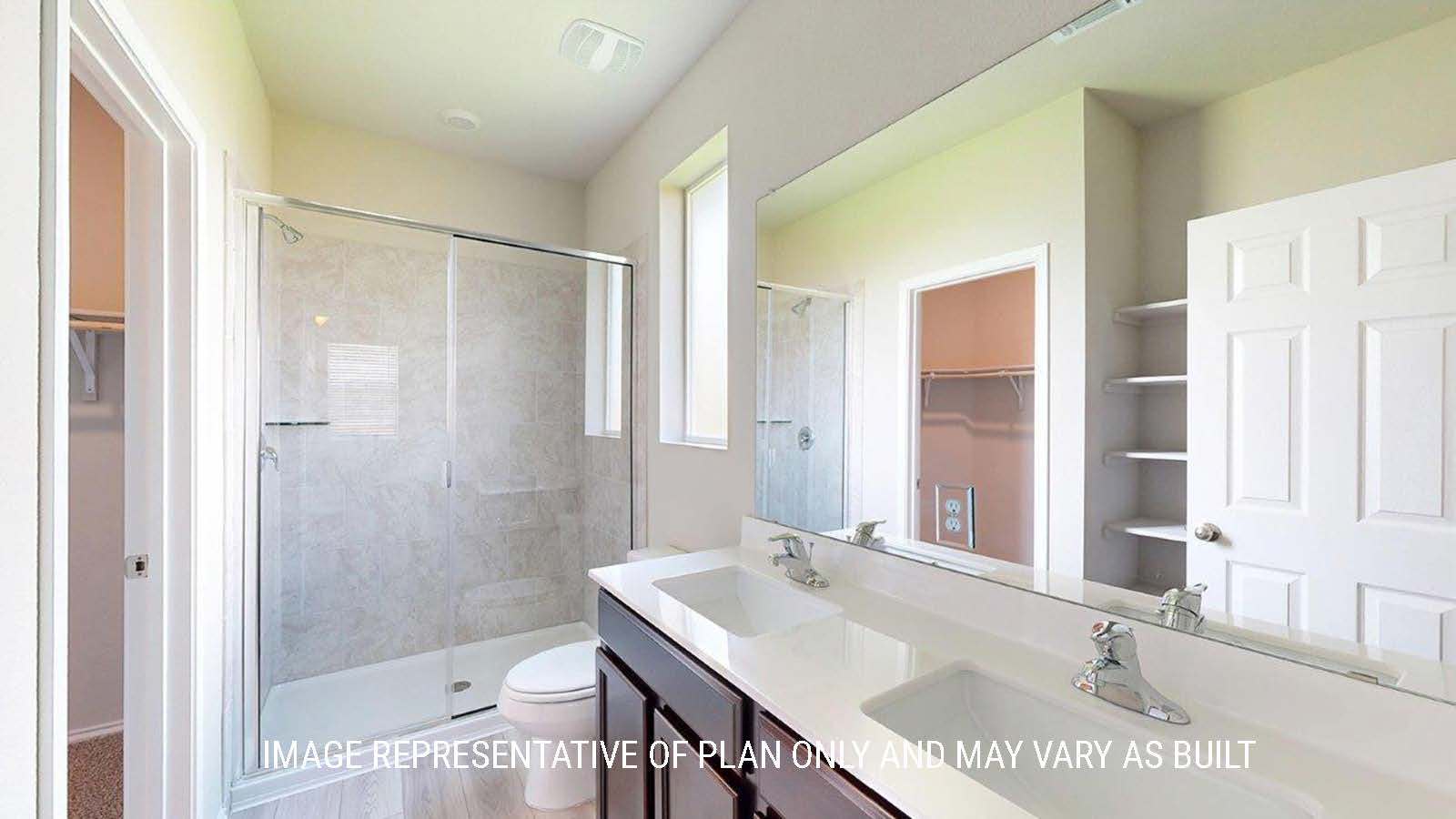 1402 Primary bathroom with duel vanity sinks and walk-in shower.