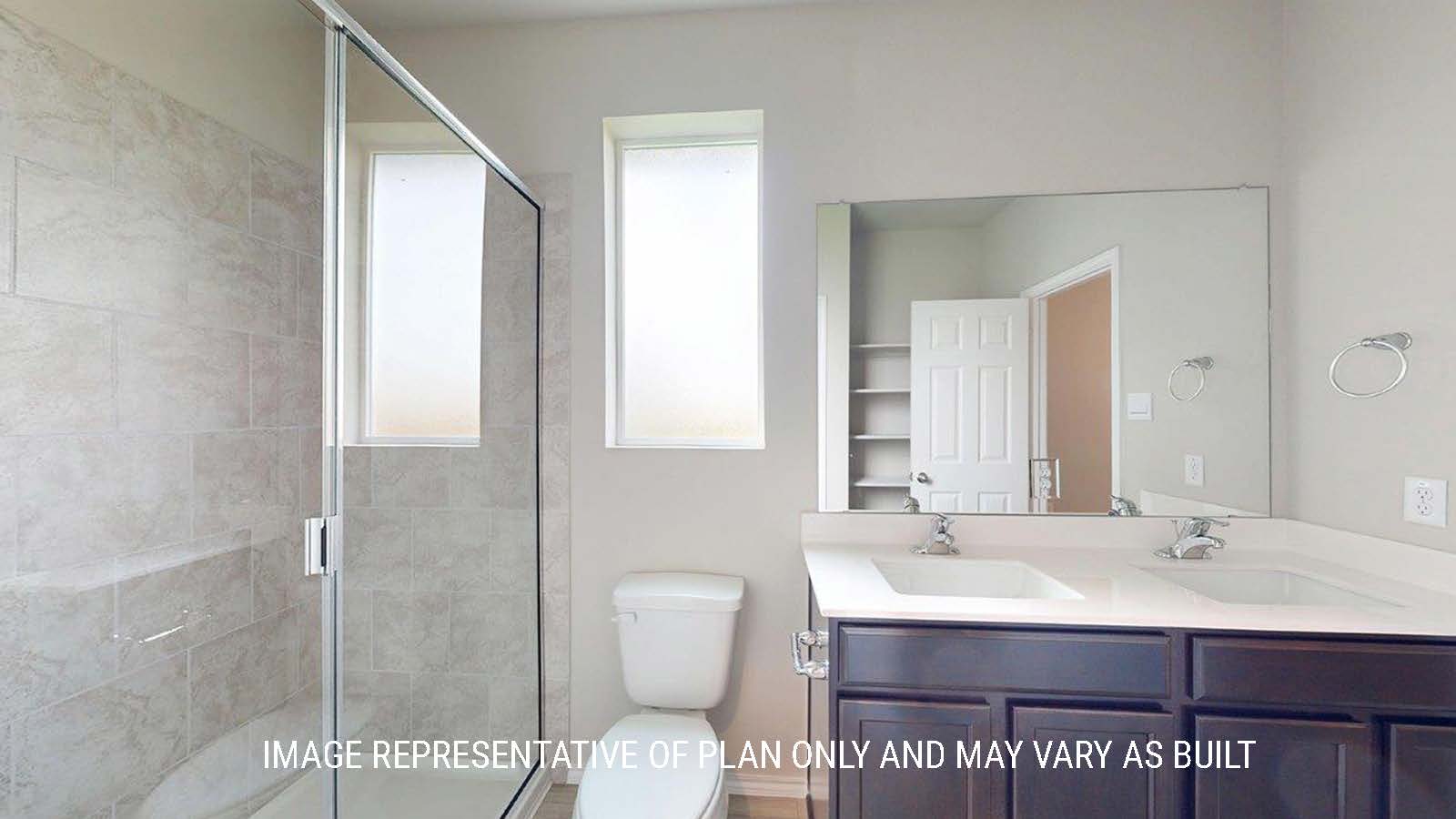 1402 Primary bathroom with duel vanity sinks and walk-in shower.