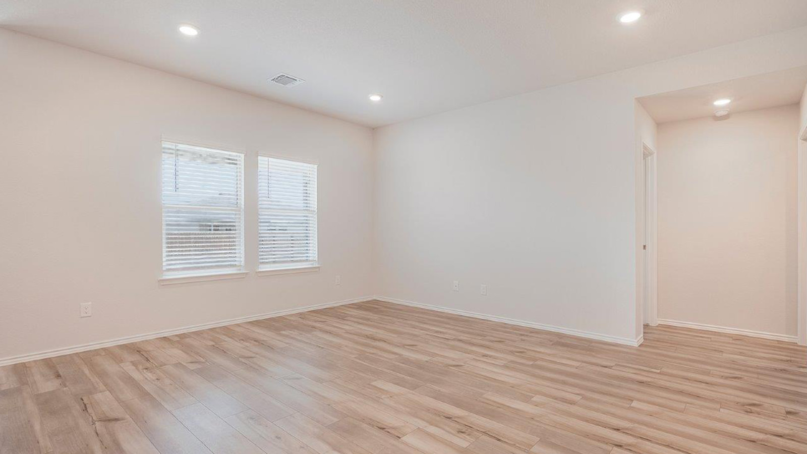 Schwertner Ranch living room with windows for natural lighting and view of back yard.