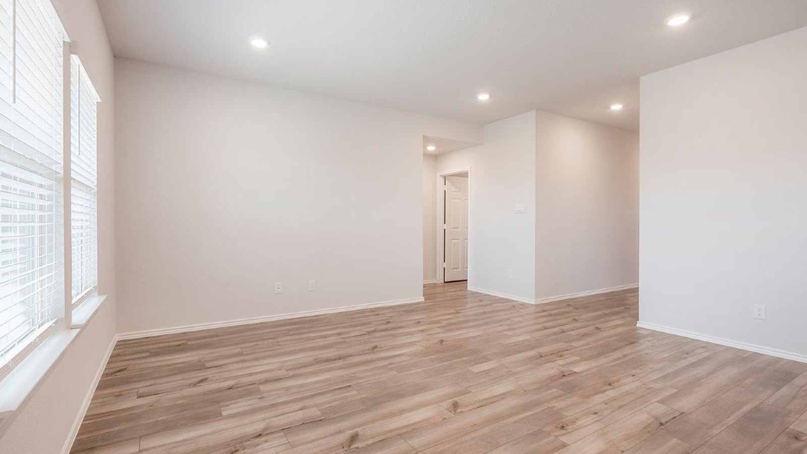 Schwertner Ranch living room with windows for natural lighting and view of back yard.