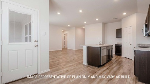 Schwertner Ranch model home dining room with view of kitchen and back door.