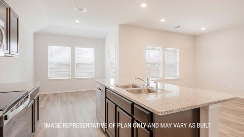 Schwertner Ranch model kitchen with center kitchen island with granite countertops and dark cabinets.