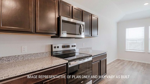 Schwertner Ranch model home kitchen with granite countertops and dark cabinets.