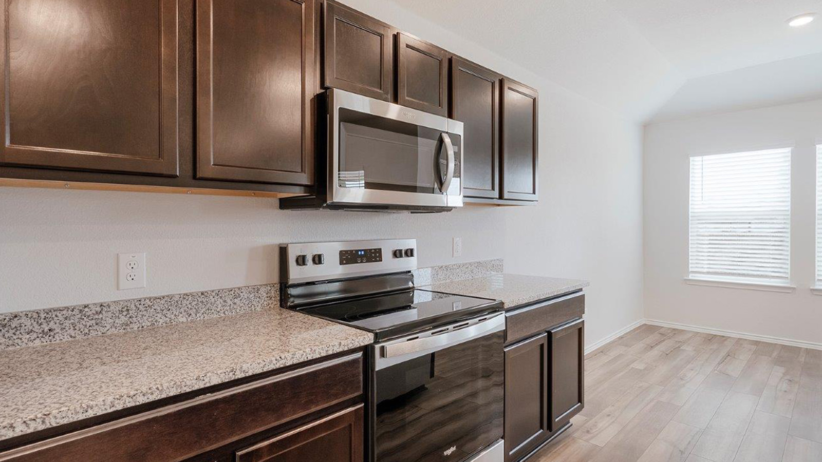 Schwertner Ranch kitchen with granite countertops and dark cabinets.