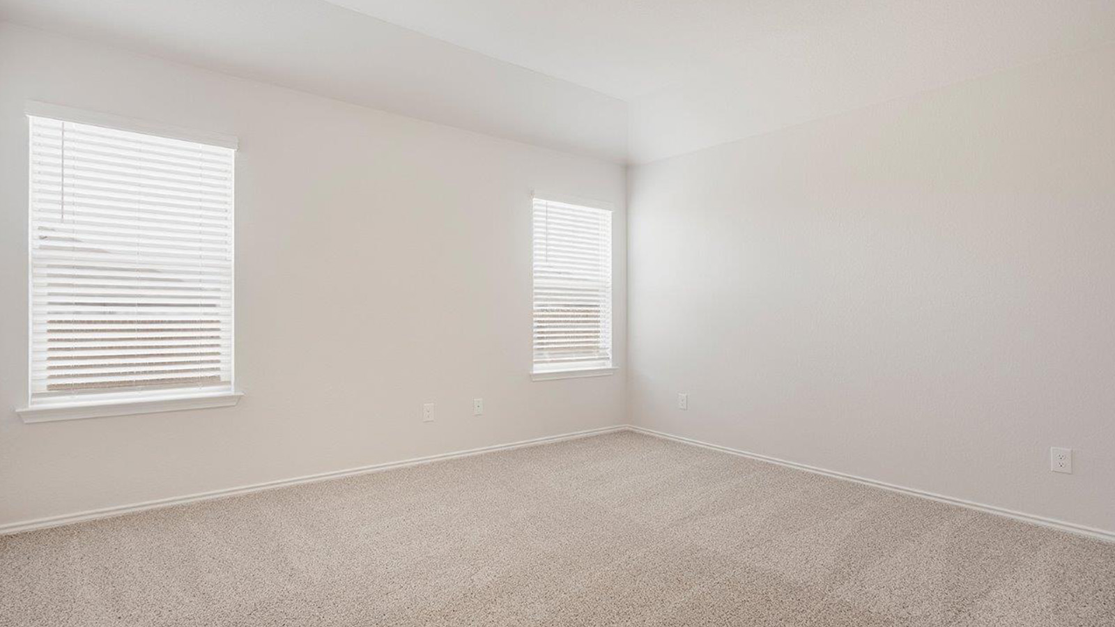 Schwertner Ranch primary bedroom with carpeted flooring and windows.
