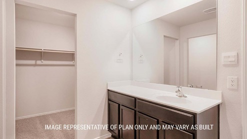 Schwertner Ranch model home primary bathroom with single vanity and view of primary closet.
