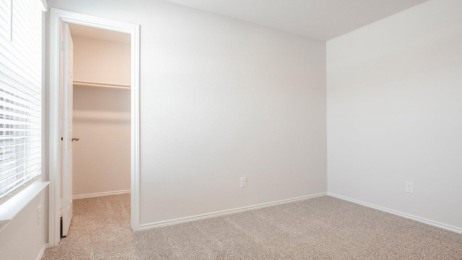 Schwertner Ranch secondary bedroom with carpeted flooring and closet.