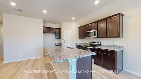 Bellvue kitchen with dark cabinets and granite countertops.