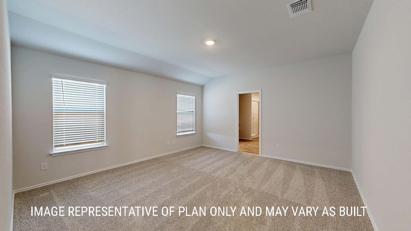 Seabrook primary bedroom with carpeted flooring and view of primary bathroom.