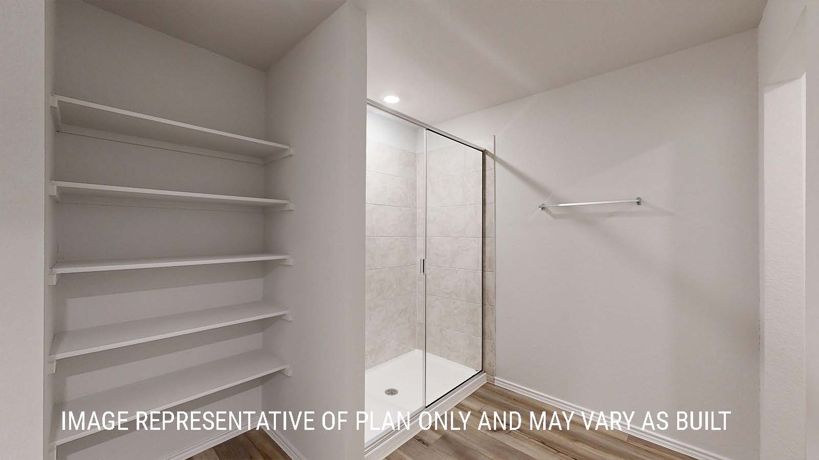 Seabrook primary bathroom with view of walk-in shower and shelving for storage.