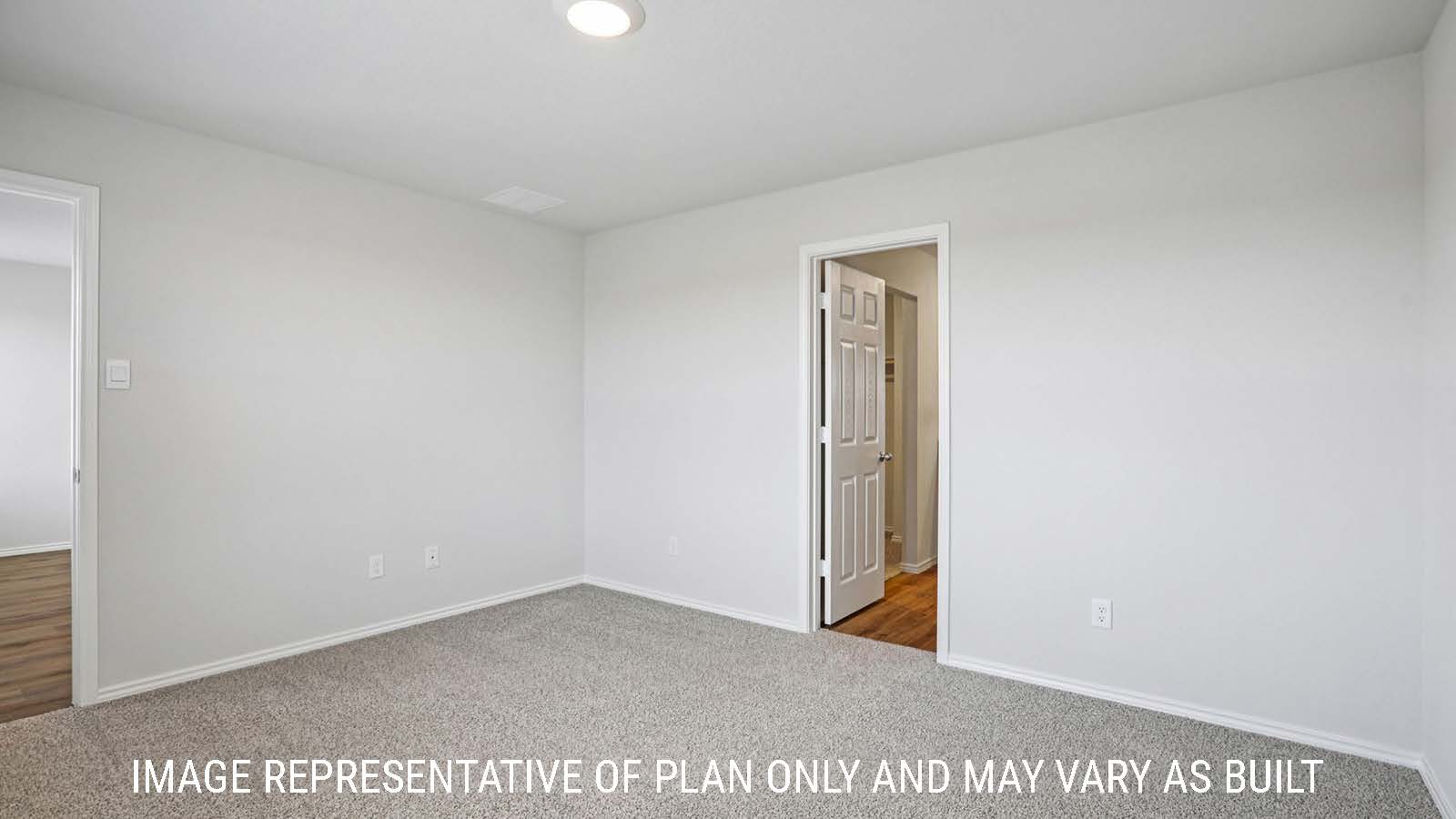 Barton primary bedroom with carpeted flooring and view of primary bathroom.