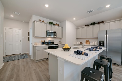 Willow Glenn model home kitchen entry with light cabinets and granite countertops.