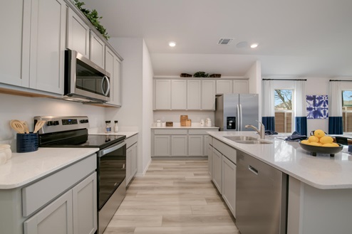Willow Glenn model home kitchen entry with light cabinets and granite countertops.