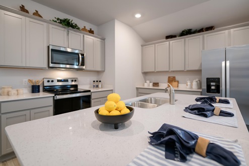 Willow Glenn model home kitchen entry with light cabinets and granite countertops.