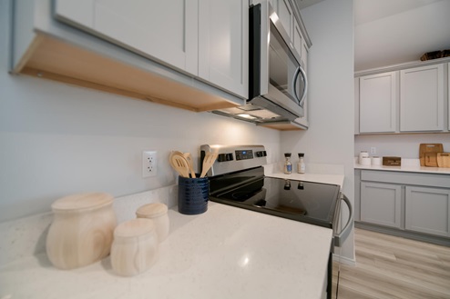 Willow Glenn model home kitchen entry with light cabinets and granite countertops.