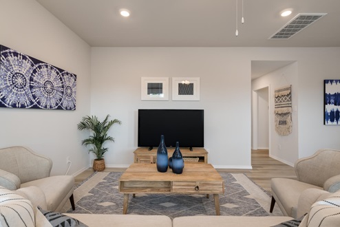 Willow Glenn model home living room with view of hallway to secondary bedroom.