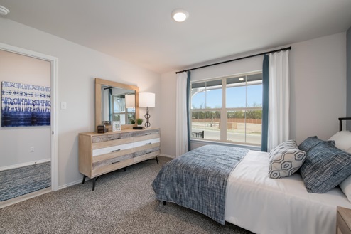 Willow Glenn model home secondary bedroom with full-size bed and accent decor.