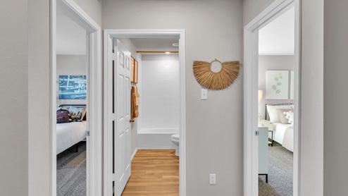 Pecan Creek model home hallway entry with view into secondary bedrooms and bathroom.