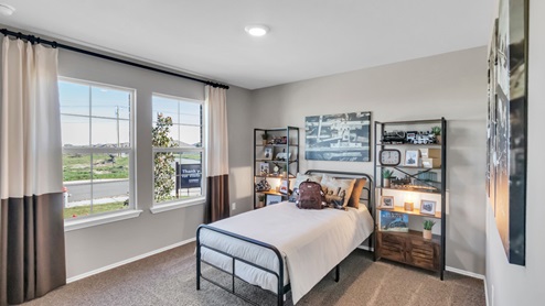 Pecan Creek model home secondary bedroom with a twin bed and carpet flooring.