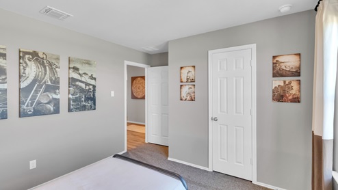 Pecan Creek model home with a twin bed and closet door.
