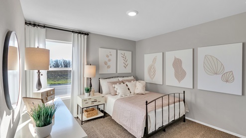 Pecan Creek model home secondary bedroom with a full-size bed and window.