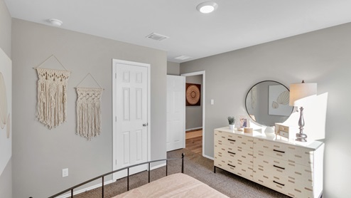 Pecan Creek model home with a full-size bed and closet door.
